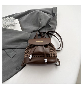Detail of vintage houndstooth backpack with brown leather flap and fashion lettering