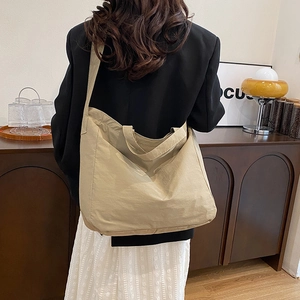 Detailed view of khaki nylon tote bag showing long shoulder strap and large capacity