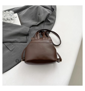 Detailed side view of brown mini backpack with leopard stitching and gold metal buckles