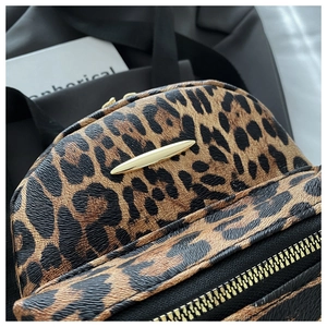 Close-up of leopard print backpack with gold spindle hardware and premium texture