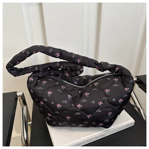Close-up of black quilted puffer bag with pink floral patterns and Beautiful lettering