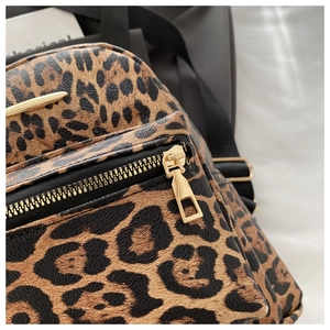 Detail of leopard print faux leather texture with high-quality gold metal zipper