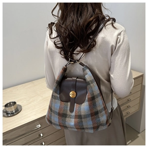 Detail of vintage plaid tweed backpack with brown leather flap and golden N buckle