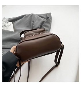 Detail of dark brown leather backpack featuring leopard print trim and drawstring bead
