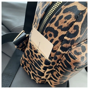 Macro shot of leopard print backpack with faux leather texture and gold zipper detail