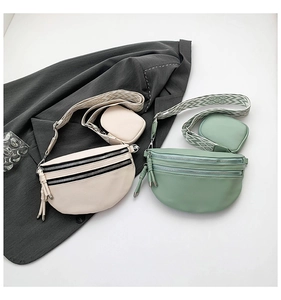 Modern leather crossbody bag with double zippers and wide geometric pattern shoulder straps