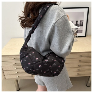 Quilted black nylon hobo bag with pink floral print and knotted shoulder strap detail