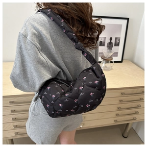 Détail du sac hobo matelassé noir avec imprimé floral rose et large bandoulière