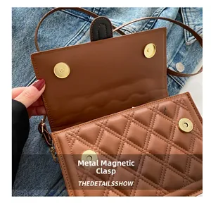 Detailaufnahme der sicheren goldenen Magnetverschlüsse an einer braunen Stepptasche