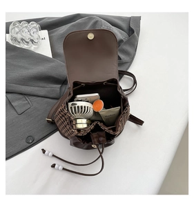 Detail view of large capacity vintage houndstooth backpack with personal daily essentials