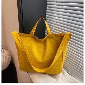 Minimalist bright yellow nylon tote bag with dual handles and long shoulder strap details