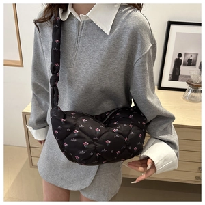 Detail of black quilted dumpling bag with pink floral pattern and beautiful script