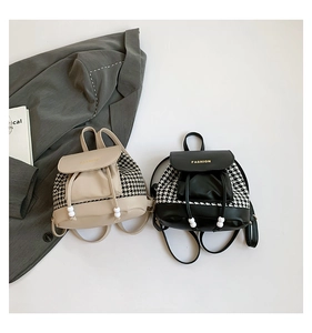 Detail of mini houndstooth backpacks in black and beige with drawstring and pearl charms