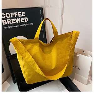 Detail of yellow nylon tote bag with crinkle texture and wide comfortable shoulder strap