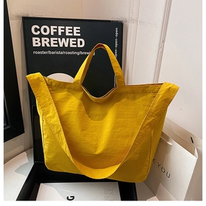 Close-up of vibrant yellow nylon tote bag showing textured waterproof fabric detail