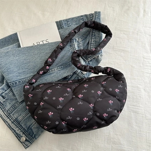 Detailed texture of black quilted down bag with pink floral and Beautiful letter print