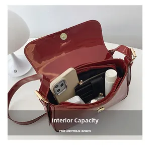 Internal view of red patent leather crossbody bag showing spacious main compartment