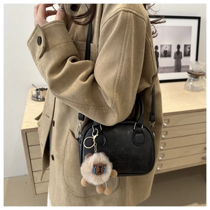 Detail of black leather bowling bag with Lucky Ohio text and plush sheep charm accessory