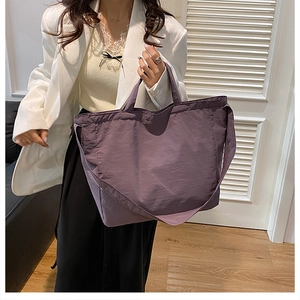 Detail of a large purple nylon tote bag with shoulder straps for commute styling