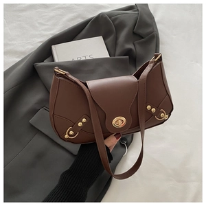 Detail of vintage brown leather underarm bag featuring gold twist lock and rivet accents