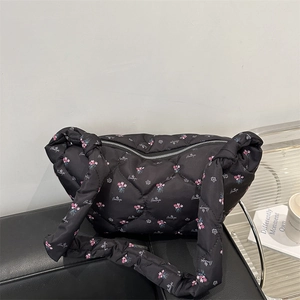 Quilted nylon down shoulder bag in black with pink floral pattern and text detail