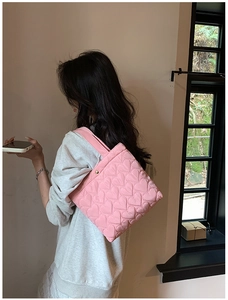 Detailed view of pink quilted heart pattern on lightweight nylon tote bag for women