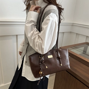 Retro dark brown faux leather tote bag with gold logo and decorative knot charm