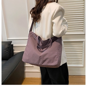 Detailed view of a purple large-capacity tote bag worn on shoulder by a model
