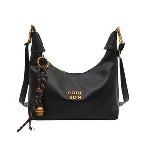 Black leather hobo bag with gold logo and decorative tassel on white background
