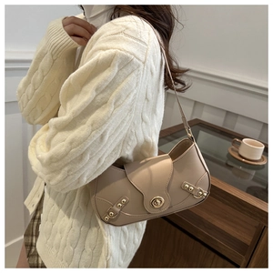 Detail of beige leather shoulder bag with gold twist lock and decorative metal rivets