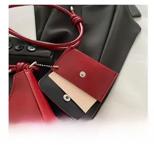 Detail of red wax leather mini bag charm with silver snap button on black background