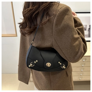 Detailed back view of a black crescent underarm bag with gold metal hardware on model