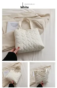 Detail of white tote bag featuring heart pattern quilting and a golden metal snap button