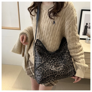 Détail du sac cabas léopard tendance avec un nœud décoratif en cuir noir élégant