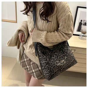 Borsa hobo leopardata con fiocco nero mostrata in un elegante outfit autunnale