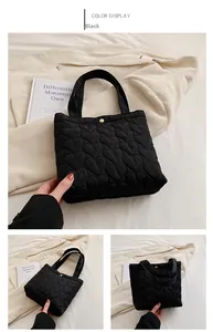Detail of black heart quilted tote bag with gold snap button and nylon texture