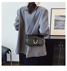 Modern black glossy patent leather shoulder bag with chic golden U-shaped buckle detail