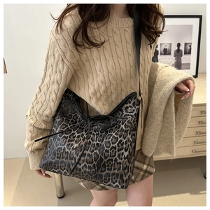 Dettaglio della borsa tote leopardata con coulisse su superficie in pelle testurizzata