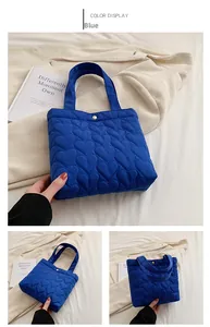 Detail of blue heart-quilted tote bag made of lightweight fabric with metal snap closure