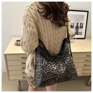 Close-up of leopard print tote bag with black bow detail showing large capacity and texture