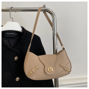 Detail of beige crescent underarm bag with gold twist lock and fine textured leather