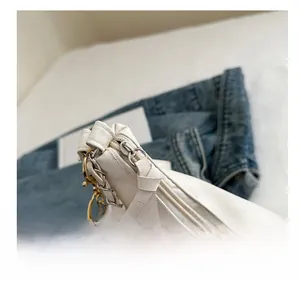 Detailed close-up of smooth zipper closure on an off-white large shoulder bag