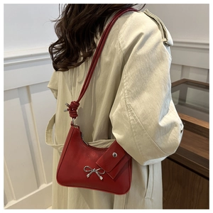 Detail of red crescent bag with silver bow accent and matching mini pouch charm