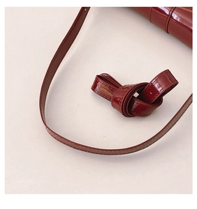 Close-up of wine red patent leather strap with high-gloss finish and fine stitching