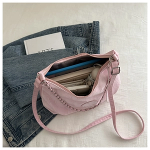 Internal capacity of pink crescent crossbody bag showing storage for tablet and umbrella