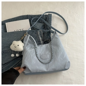 Close-up of light blue shoulder bag with pleated fabric texture and cloud charm