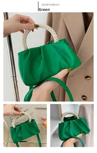 Dettaglio della borsa nuvola verde con manico di perle e tracolla in pelle regolabile