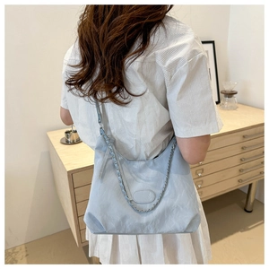 Detail of light blue pleated hobo bag with adjustable strap and silver metal chain strap