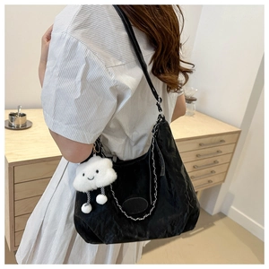 Detail of black crescent shoulder bag with silver chain and white plush cloud charm