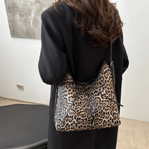 Chic leopard print oversized tote bag with black bow detail worn over a black blazer